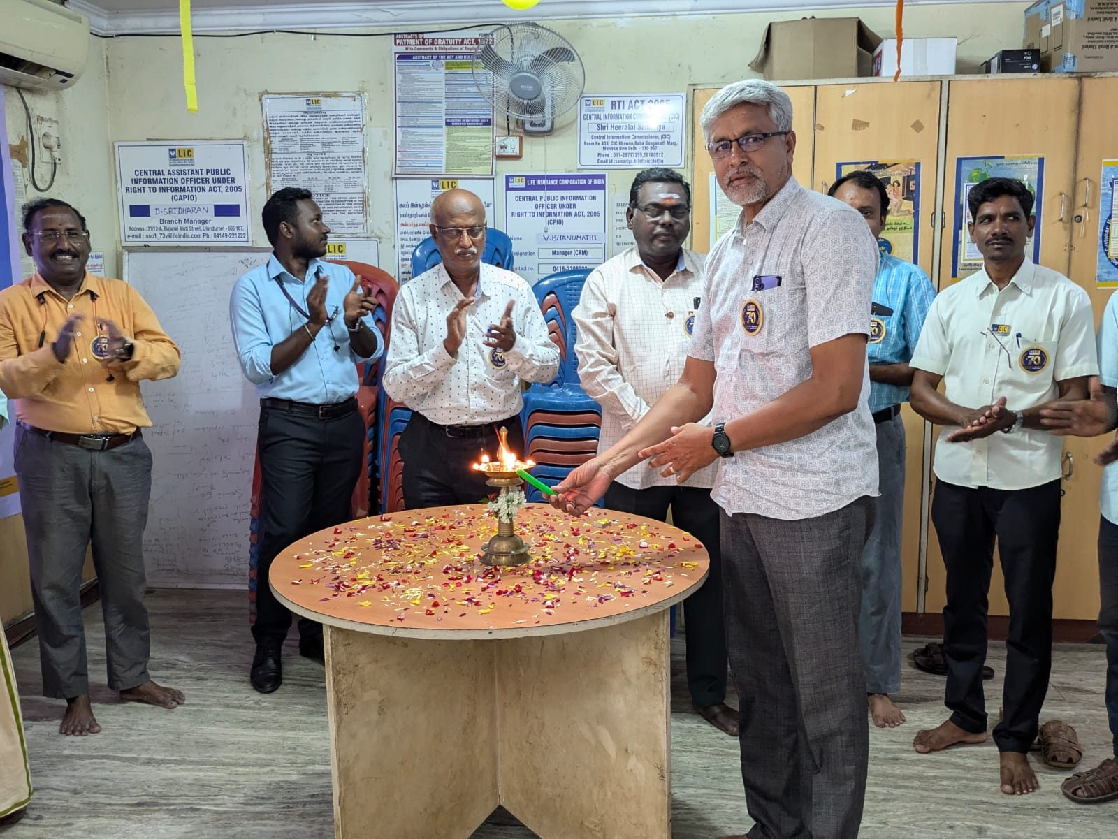 G. Selvakumar lighting a ceremonial lamp at a branch celebration