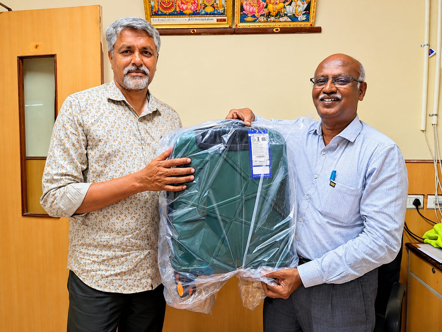 G. Selvakumar receiving a travel trolley bag as a recognition gift